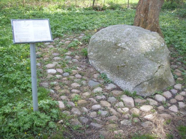 Ved siden af stenen er en tavle med information